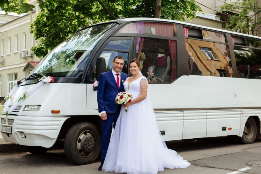 Couple in front of wedding bus